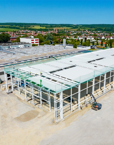 Kemmlit Industrie­halle Teil­schlüssel­fertig von der Ecke. Drohnenaufnahme vom laufenden Projekt.